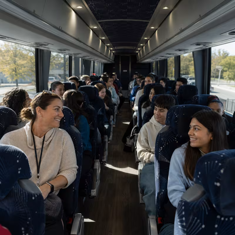 Group boarding a white charter bus for School Transportation transportation in McKinney