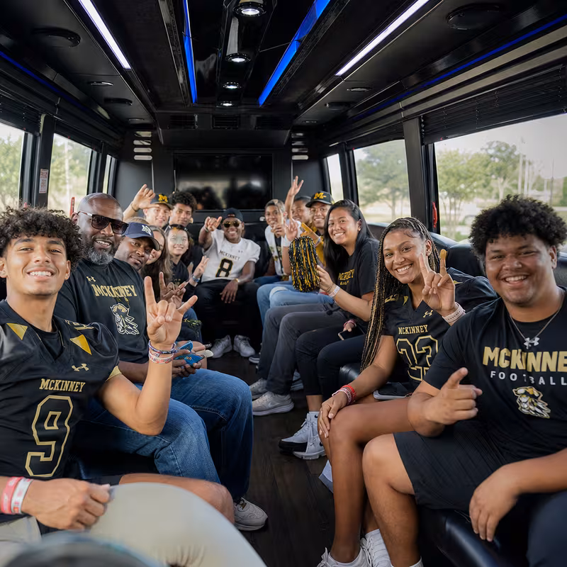 Group boarding a white charter bus for Sporting Event Transportation transportation in McKinney